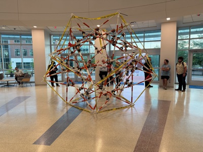 The completed sculpture in the atrium in evening light, with the glass entrance behind it